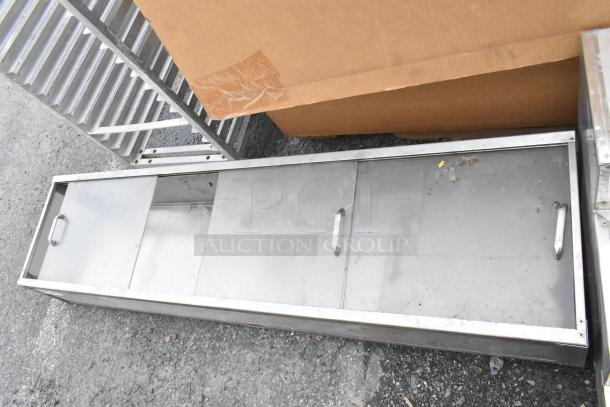 Metal cabinet with clear sliding doors, metal handles, and moderate wear, ideal for storage or display purposes.