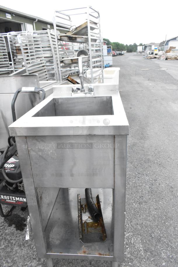 Stainless steel single bay sink with faucet and handles, industrial-grade, visible discoloration, no visible brand markings.