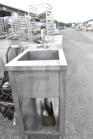 Stainless steel single bay sink with faucet and handles, industrial-grade, visible discoloration, no visible brand markings.
