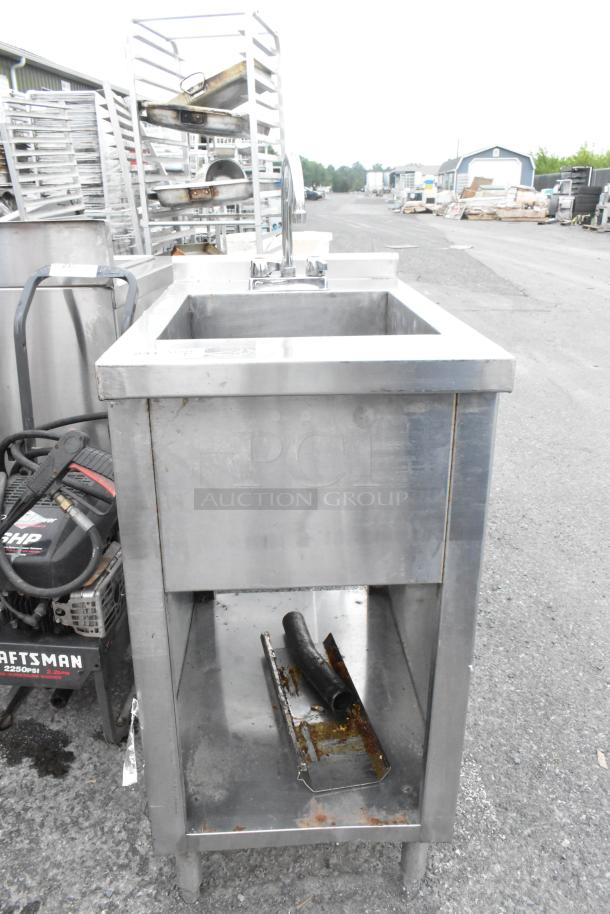 Stainless steel single bay sink with faucet and handles, features sturdy construction and visible wear, ideal for commercial use.
