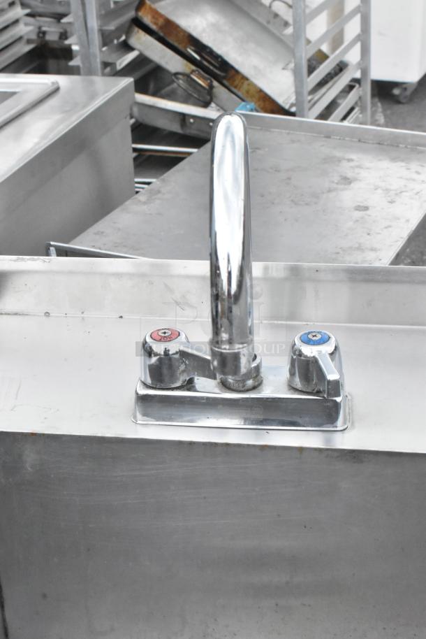 Stainless steel single bay sink with chrome faucet and hot/cold handles in good condition. Ideal for commercial use.
