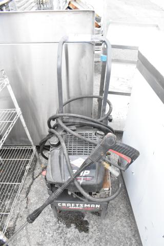 Craftsman 580.762250 Pressure Washer, black, used, with coiled hose and spray nozzle. Visible brand logo and model.