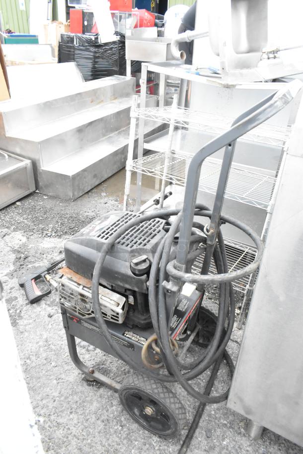 Craftsman 580.762250 Pressure Washer, black, hose coiled, used condition, visible wear, sturdy wheels, metal frame.