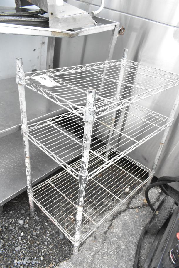 Chrome finish 3-tier wire shelving unit with visible wear, buyer must dismantle. Ideal for storage, consider freight charges.