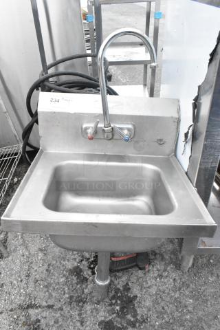 Stainless steel single bay wall mount sink with faucet and dual handles, lightly used, minor surface wear.