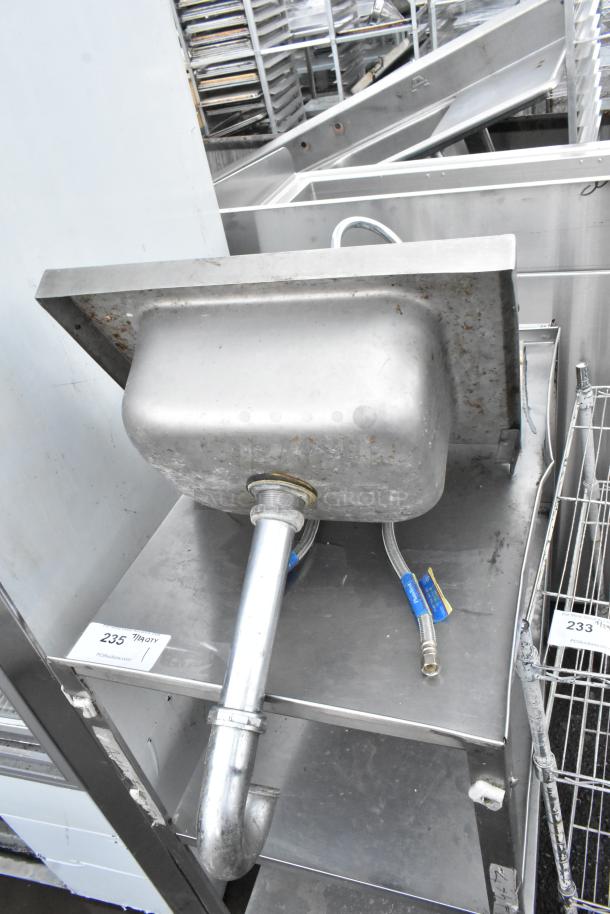 Stainless steel single bay wall mount sink with faucet and handles, visible wear, includes plumbing fixtures, auction tag 235.