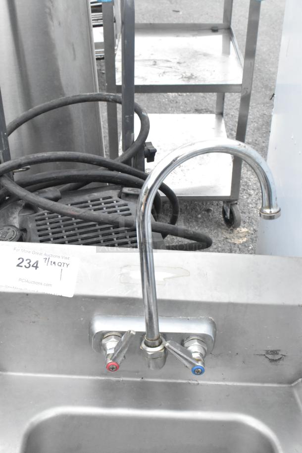 Stainless steel wall mount sink with faucet and handles, used condition. Auction tag visible with item number 234.