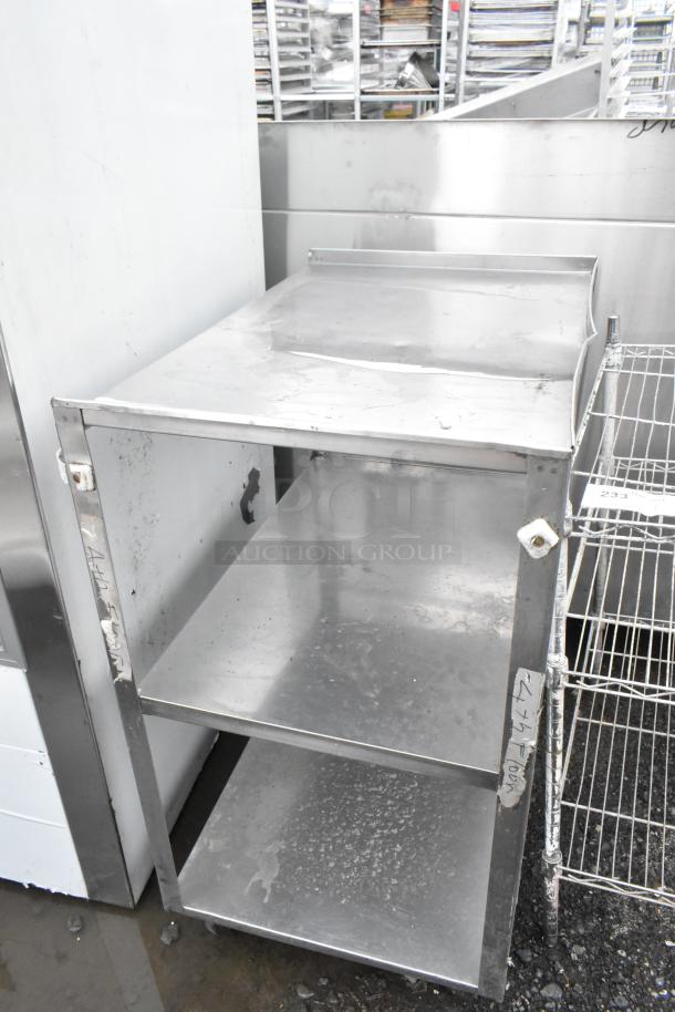Metal 3-tier cart on commercial casters, used condition, features three shelves, sturdy metal build, signs of wear visible.