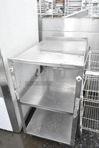 Metal 3-tier cart on commercial casters, used condition, features three shelves, sturdy metal build, signs of wear visible.