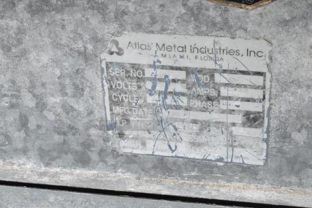 Atlas Metal stainless steel ice bin with right side sink, commercial-grade, visible wear, label with manufacturer details.