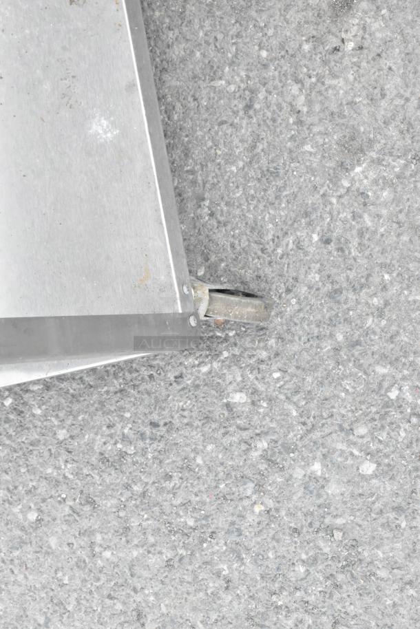 Close-up of Lakeside Metal 3 Tier Cart corner with commercial caster, showing metal texture and caster condition.