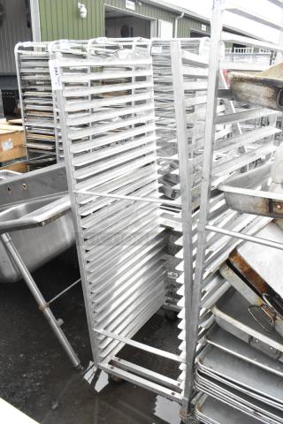 Metal commercial pan transport rack on casters, showing multiple shelves for storage, in used condition. Marked "243."