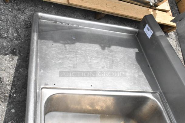 Stainless steel 2 bay sink with dual drain boards, no legs. Slight surface wear visible. Auction tag reads "Lot 244".