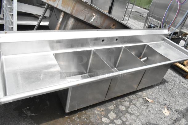 Stainless steel 3 bay sink with dual drain boards, featuring durable construction and multiple compartments, ideal for commercial use.
