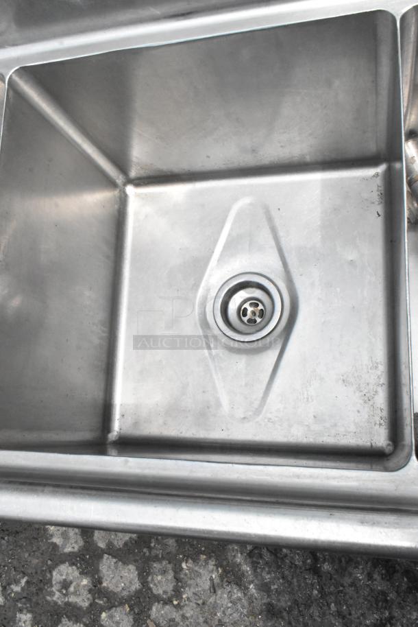 Stainless steel 3 bay sink with dual drain boards, visible drainage detail, good condition, ideal for commercial kitchens.