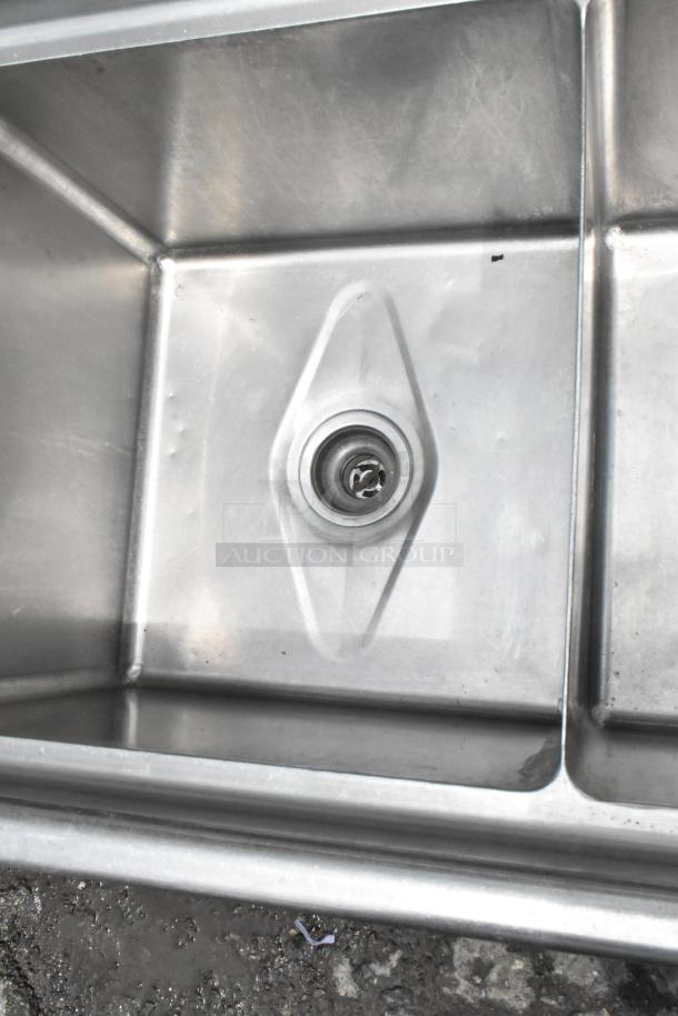 Stainless Steel 3 Bay Sink with dual drain boards, commercial-grade, slightly used condition, visible drain detail.