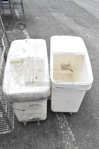 Two white poly ingredient bins on commercial casters, showing signs of wear and residue. One bin is wrapped in plastic.