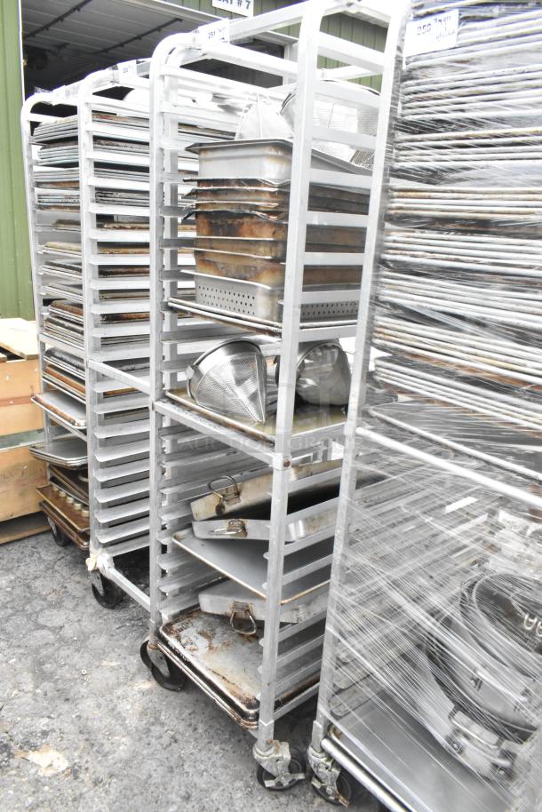 Metal pan transport rack on commercial casters with 7 full-size baking pans and 8 drop-in bins. Moderate wear.