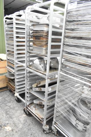 Metal pan transport rack on commercial casters with 7 full-size baking pans and 8 drop-in bins. Moderate wear.