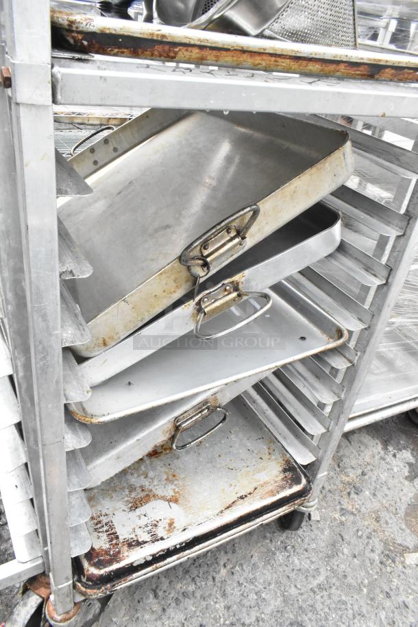 Metal pan transport rack with commercial casters, containing 7 full-size baking pans and 8 drop-in bins. Used condition.