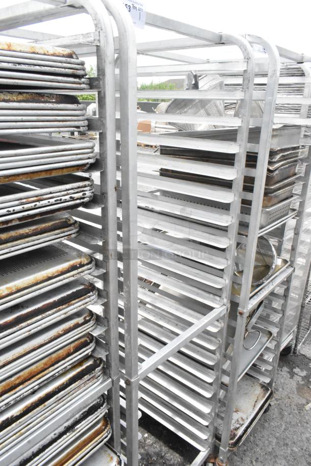 Commercial metal pan transport rack with multiple shelves, on casters for mobility. Slight wear on surfaces; suitable for bakery or kitchen use.