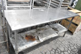 Stainless steel table with metal under shelf, showing signs of wear and rust. Tag "255 lbs qty" visible.