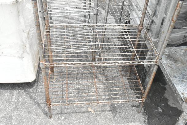 Chrome finish 5-tier wire shelving unit with some rust, requiring buyer dismantlement; consider freight charges.