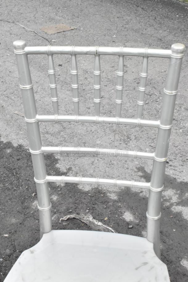 Silver Chiavari stackable banquet chair with a bamboo-like frame, showing light wear and suitable for events. Total of 76 chairs available.