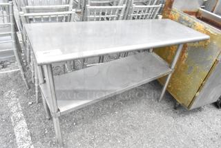 Stainless steel table with metal under shelf, rectangular shape, shows signs of use, labeled "263" on top corner.