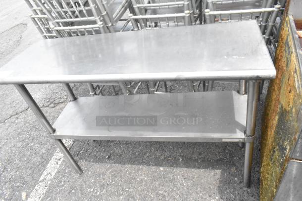 Stainless steel table with metal under shelf, sturdy construction, suitable for industrial use, good condition.
