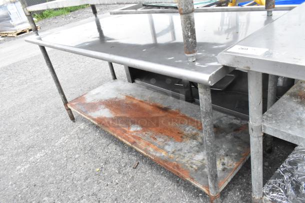Stainless steel table with metal under shelf, measures 72x30x35 inches. Moderate wear, visible rust on the lower shelf.