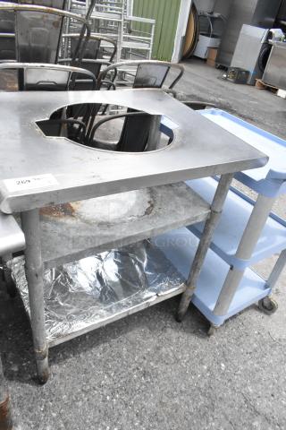 Stainless steel sauce table with cut-out, two metal under shelves, visible wear, auction tag number 269.