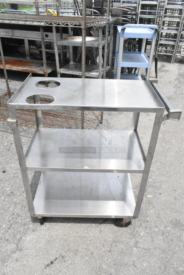 Three stainless steel 3-tier carts on commercial casters, sturdy design, minor surface wear, ideal for industrial use.
