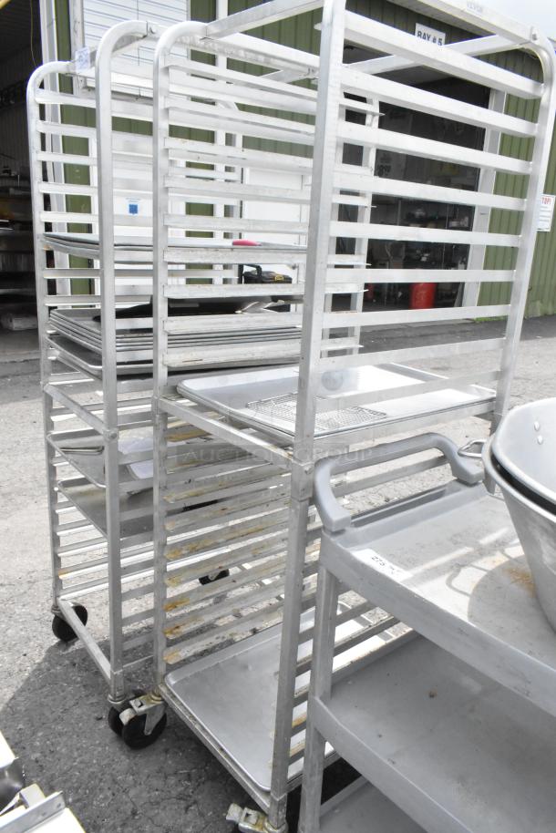 Two metal pan transport racks on commercial casters, durable, with multiple shelves for efficient storage.
