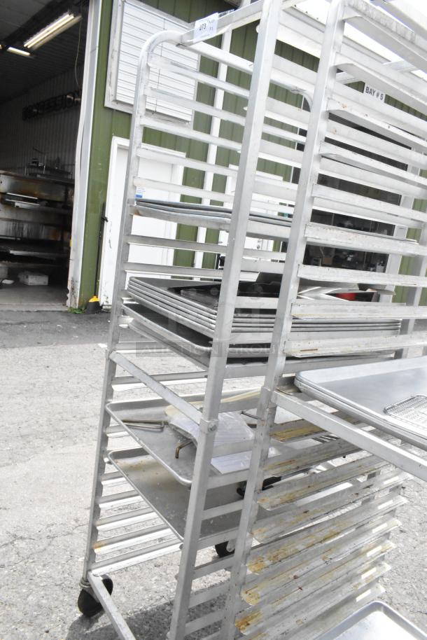 Two metal pan transport racks with commercial casters, suitable for bakery or restaurant use, in used condition.