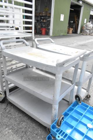 2 Tan Poly 3-tier carts with commercial casters, used condition, visible wear. Durable and mobile, ideal for industrial use.