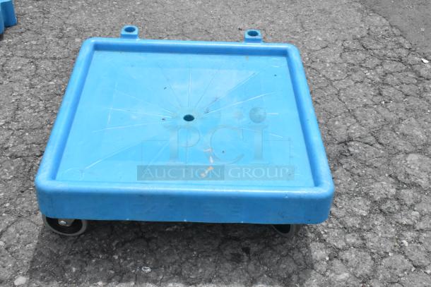 Blue polyethylene dolly on commercial casters, durable, with integrated handles, lightly worn. Suitable for heavy loads.