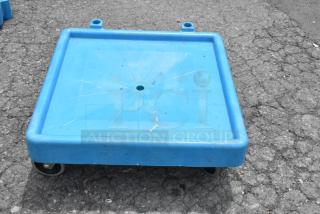 Blue polyethylene dolly on commercial casters, durable, with integrated handles, lightly worn. Suitable for heavy loads.