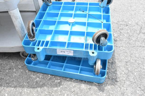 Two blue poly dollies with commercial casters, durable design, good condition, labeled "276," ideal for heavy loads.