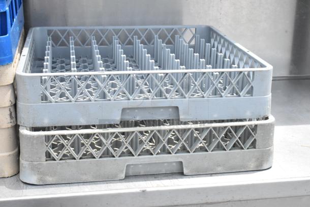 Five various poly dish caddies in gray, stacked. Used condition with visible wear. Ideal for dish storage and transport.