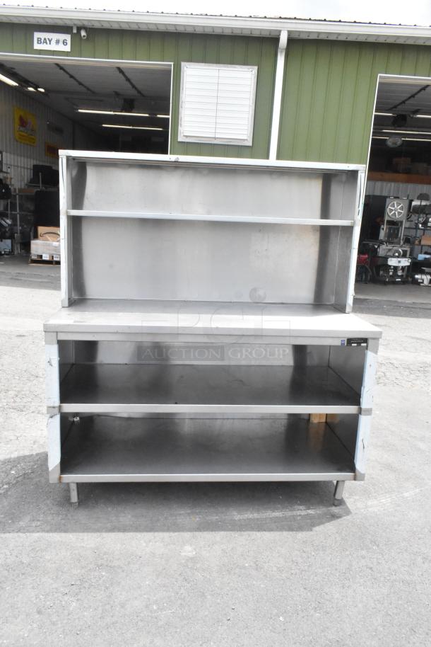 Stainless steel table with over shelf and two under shelves, durable design, used condition, ideal for storage and workspace.