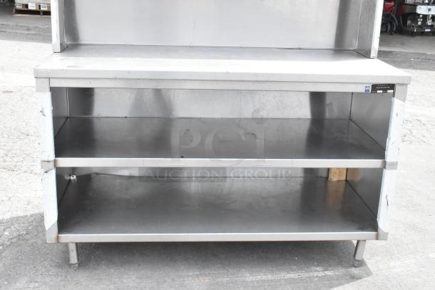 Stainless steel table with over shelf and two under shelves, in good condition. Ideal for kitchen or storage use.