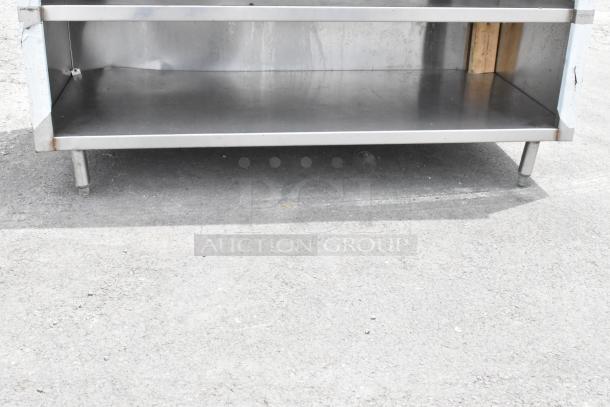 Stainless steel table with over shelf and two under shelves, durable construction, ideal for industrial use.