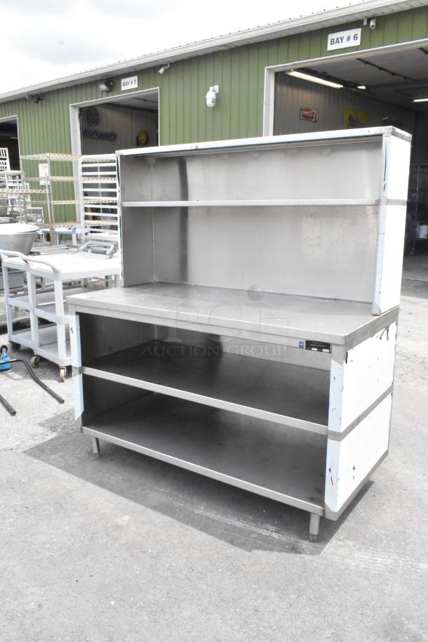 Stainless steel table with over shelf and 2 under shelves. Durable condition, ideal for kitchen or storage use.