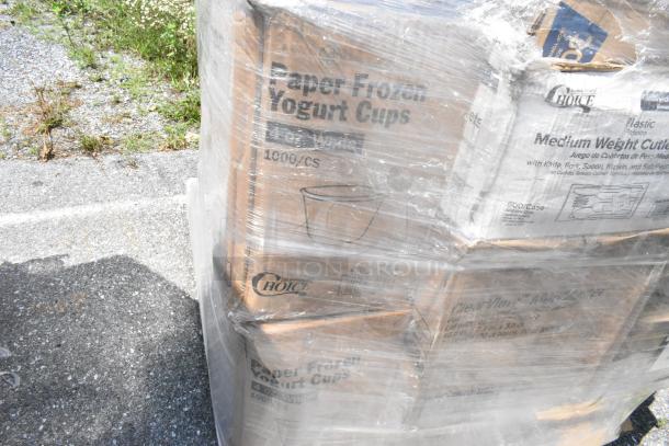 Auction item featuring 24 boxes of new, scratch and dent supplies: yogurt cups, cutlery sets, wrapped on a pallet. Items are sealed in plastic.
