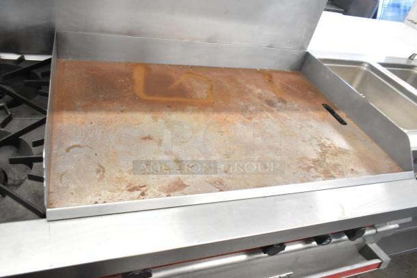 Vulcan stainless steel 4-burner range, right-side flat top griddle, dual ovens, over shelf, backsplash; used condition.