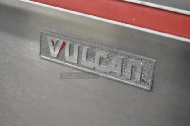 Vulcan stainless steel gas range with 4 burners, convection oven, standard oven, griddle, over shelf, and backsplash.
