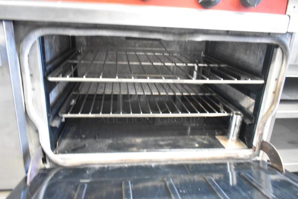 Vulcan Stainless Steel 4 Burner Range with side griddle and dual ovens. Features an overshelf and backsplash.