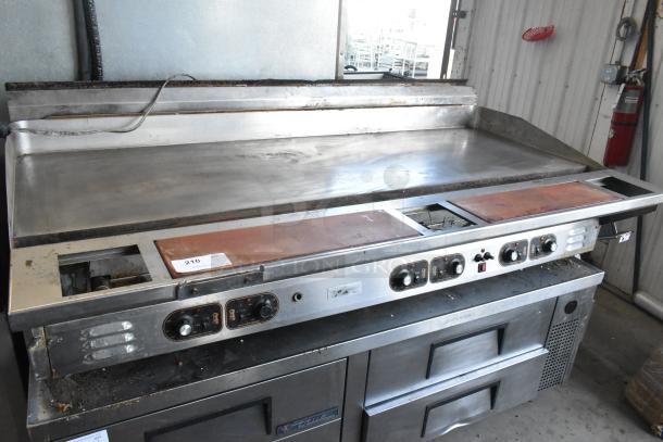 Stainless steel commercial countertop flat top griddle with control knobs, showing signs of use, ideal for restaurant kitchens.