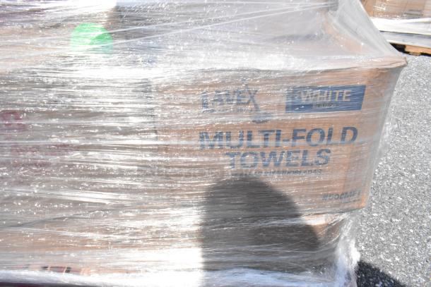 Pallet wrapped items including Lavex multi-fold towels. Markings indicate white towels, scratch and dent condition.